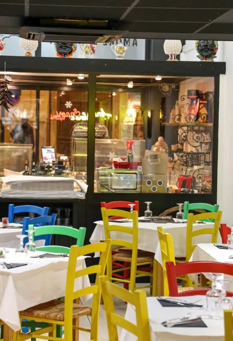 La salle colorée d'Amore e Sapori avec ses chaises peintes